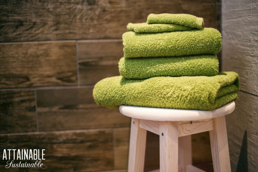 Do you really need all that baby paraphernalia? Adopting a minimalist parenting attitude can save you a bundle. Check out 5 Tips for Ditching consumerism. 绿色的毛巾堆在木凳上