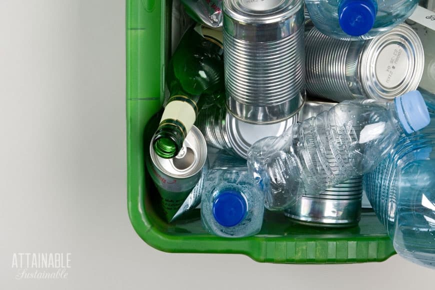 Breaking up with disposable waste is possible - here's how. Implement these easy-to-adopt tactics to reduce waste in your household & send less to the dump. 可回收的锡和塑料在一个绿色的垃圾箱从上面