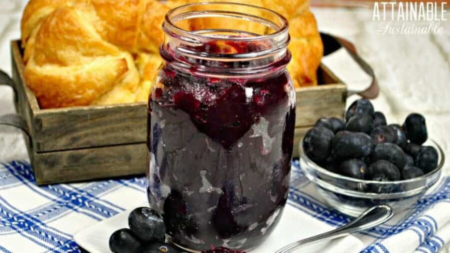 blueberry jam in a canning jar with croissants in the background