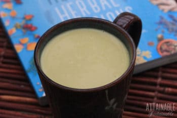 turmeric milk in a mug, with bright blue book behind